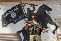 <p>A member of Turkish-backed Free Syrian Army (FSA), seen with a mural of the Islamic State in the background, stands guard in front of a building in the border town of Jarablus, Syria, Aug. 31, 2016. (Photo: Umit Bektas/Reuters)</p>