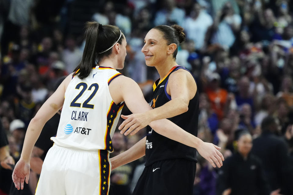 Indiana Fever guard Caitlin Clark (22) gets a hug from Phoenix Mercury guard Diana Taurasi, right, prior to a WNBA basketball game, Sunday, June 30, 2024, in Phoenix. (AP Photo/Ross D. Franklin)