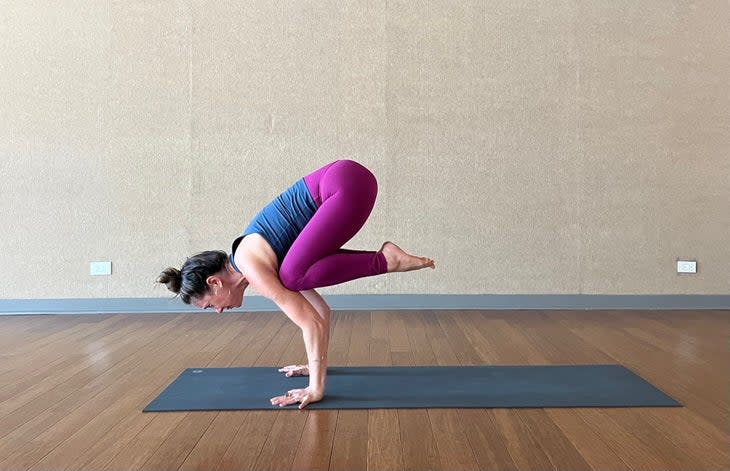 Woman learning how to do Crow Pose
