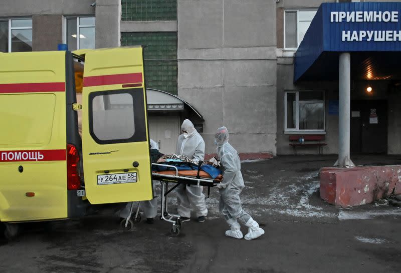 FILE PHOTO: Paramedics pull a stretcher out of an ambulance while transporting a patient amid the coronavirus disease outbreak in Omsk
