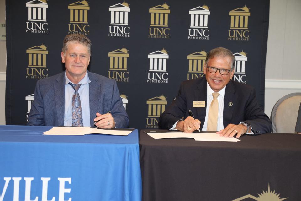 Blair Fisher (left), Head of School at Fayetteville Academy and Chancellor Robin Gary Cummings sign an agreement establishing the UNCP and Fayetteville Academy Joint Enrollment Partnership