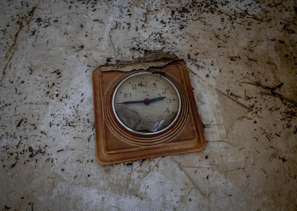 A damaged clock from last year's floods hangs on a wall in the village of Schuld in the Ahrtal valley, Germany, Tuesday, July 5, 2022. Flooding caused by heavy rain hit the region on July 14, 2021 causing the death of about 130 people. (AP Photo/Michael Probst)