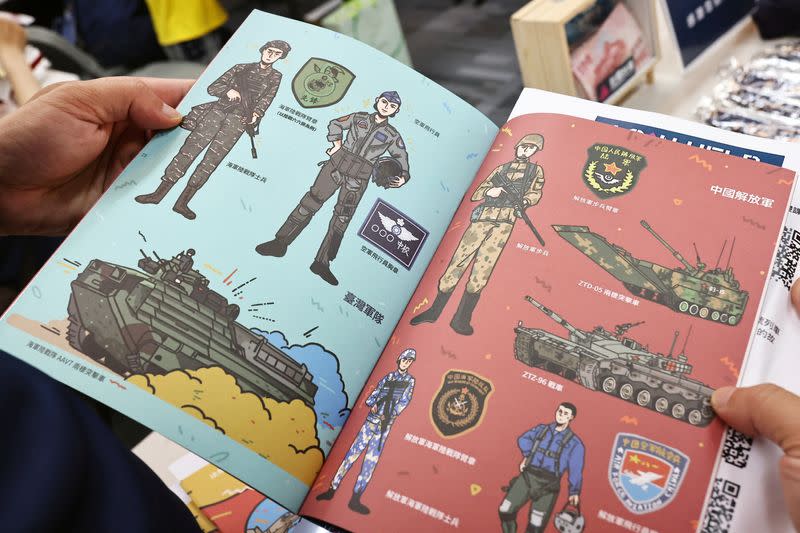 FILE PHOTO: A person holds a booklet with illustrations of Taiwan armed forces and Chinese People's Liberation Army in Taipei