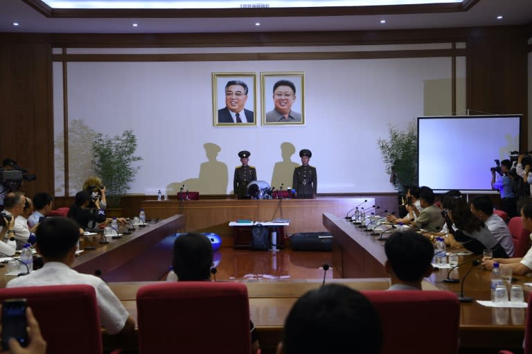 Ko Hyon-Chol, sitting below framed photos of Kim Il-Sung and Kim Jong-Il, "confessed" to attempted child abduction