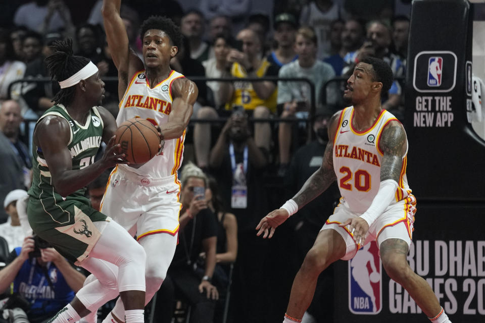 De'Andre Hunter of Atlanta Hawks guards Jrue Holiday of Milwaukee Bucks during a preseason NBA basketball game in Abu Dhabi, United Arab Emirates, Saturday, Oct. 8, 2022. (AP Photo/Kamran Jebreili)