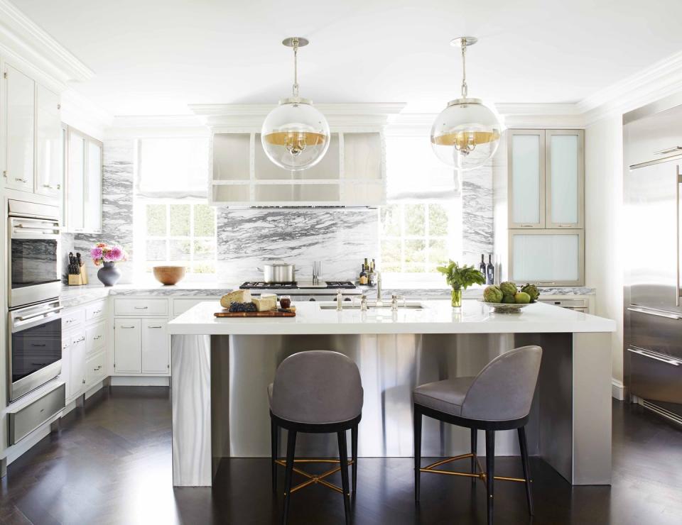 <p>Designer <a href="http://jamesmichaelhoward.com/" rel="nofollow noopener" target="_blank" data-ylk="slk:James Michael Howard" class="link ">James Michael Howard</a> anchored this modern, all-white kitchen in Westchester, New York, by extending the Breccia Imperiale marble countertop and backsplash up to the ceiling on the wall behind the range. The stone's organic pattern provides a focal point within the open-plan space. The refrigerator is <a href="https://www.subzero-wolf.com/planning-resources/brochure-request?PID=ppcawareness_subzero_2019%3Agoogle%3Acpc%3Asz_brand_awareness%3Apaidsearch&promoID=Q6UJ9A5482QF&s_kwcid=AL%218224%213%21274366935293%21e%21%21g%21%21subzero&gclid=Cj0KCQjw19DlBRCSARIsAOnfRehWfShQSNpj0675F1Hl0Hy__-0lVbnvTwTi2-bVi6gIGA5cyRDy0xAaAhqgEALw_wcB" rel="nofollow noopener" target="_blank" data-ylk="slk:Sub-Zero" class="link ">Sub-Zero</a>, the range is <a href="https://www.subzero-wolf.com/wolf" rel="nofollow noopener" target="_blank" data-ylk="slk:Wolf" class="link ">Wolf</a>, the globe pendants are <a href="https://urbanelectric.com/" rel="nofollow noopener" target="_blank" data-ylk="slk:The Urban Electric Co." class="link ">The Urban Electric Co.</a>, and the barstools are Suzanne Kasler for <a href="http://www.hickorychair.com/" rel="nofollow noopener" target="_blank" data-ylk="slk:Hickory Chair." class="link ">Hickory Chair.</a></p>