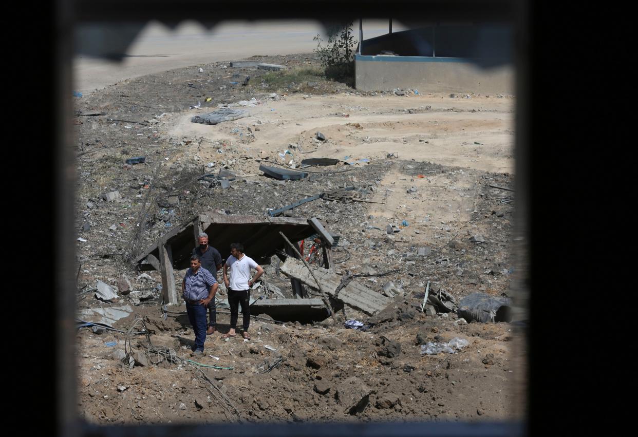 Palestinians inspect the rubble of an ice factory and mechanics garage destroyed by Israeli airstrikes in Gaza City, Tuesday, May 11, 2021.