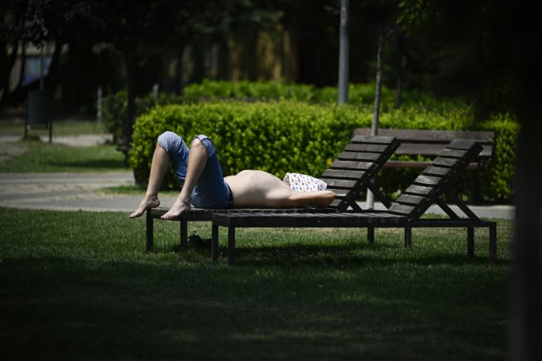 Una persona se solea en un banco de un parque público bajo 42ºC de calor en Sofía, capital de Bulgaria, el 18 de julio de 2024 (Nikolay DOYCHINOV)