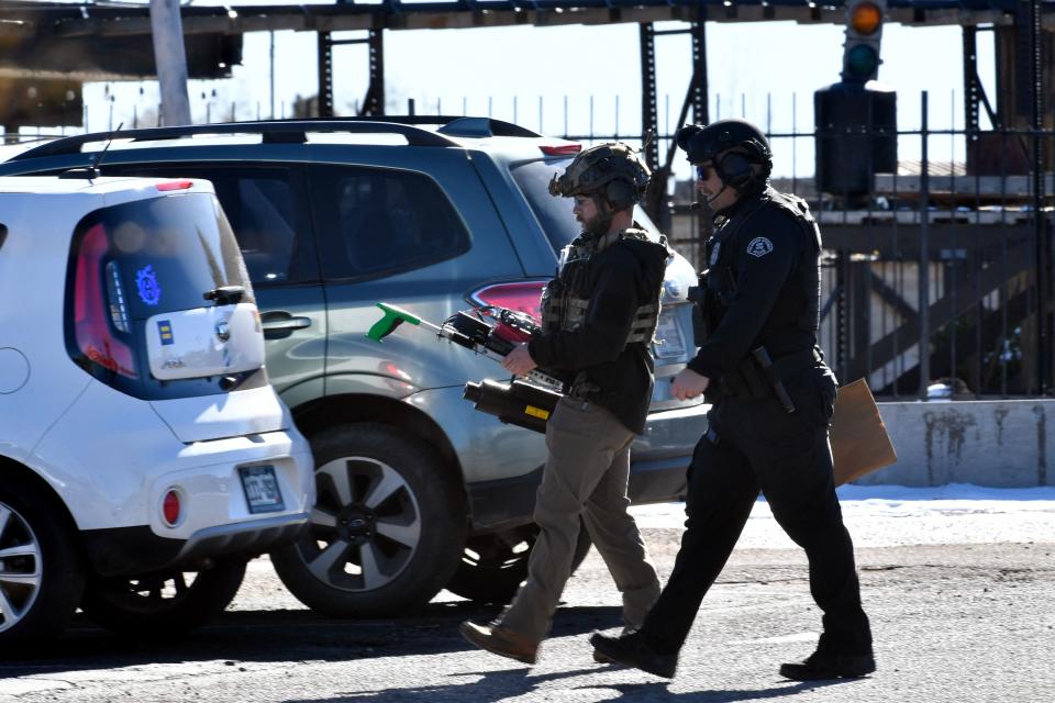 Law enforcement officers walk through the parking lot of Club Q, an LGBTQ nightclub, in Colorado Springs, Colorado, on November 20, 2022. - At least five people were killed and 18 wounded in a mass shooting at an LGBTQ nightclub in the US city of Colorado Springs, police said on November 20, 2022. (Photo by Jason Connolly / AFP) (Photo by JASON CONNOLLY/AFP via Getty Images)