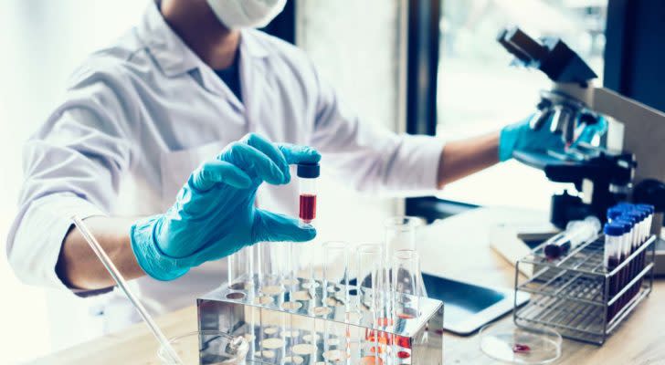 MNMD stock: A scientist holding a test tube in a stock image. AI Recommended Biotech Stocks