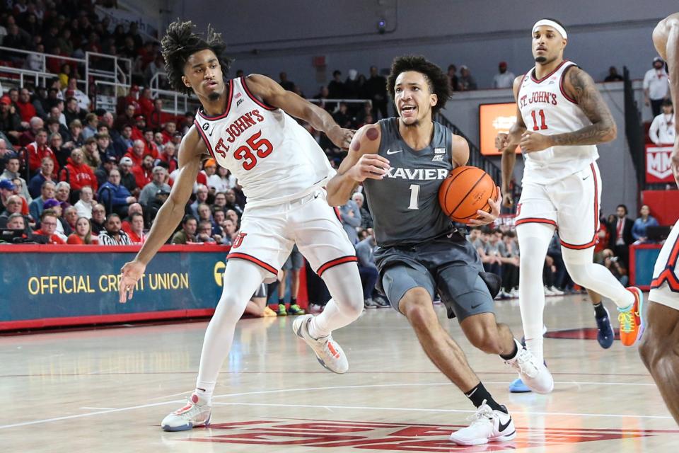 Dec 20, 2023; Queens, New York, USA; Xavier Musketeers guard Desmond Claude (1) drives past St. John's Red Storm forward Glenn Taylor Jr. (35) in the first half at Carnesecca Arena.