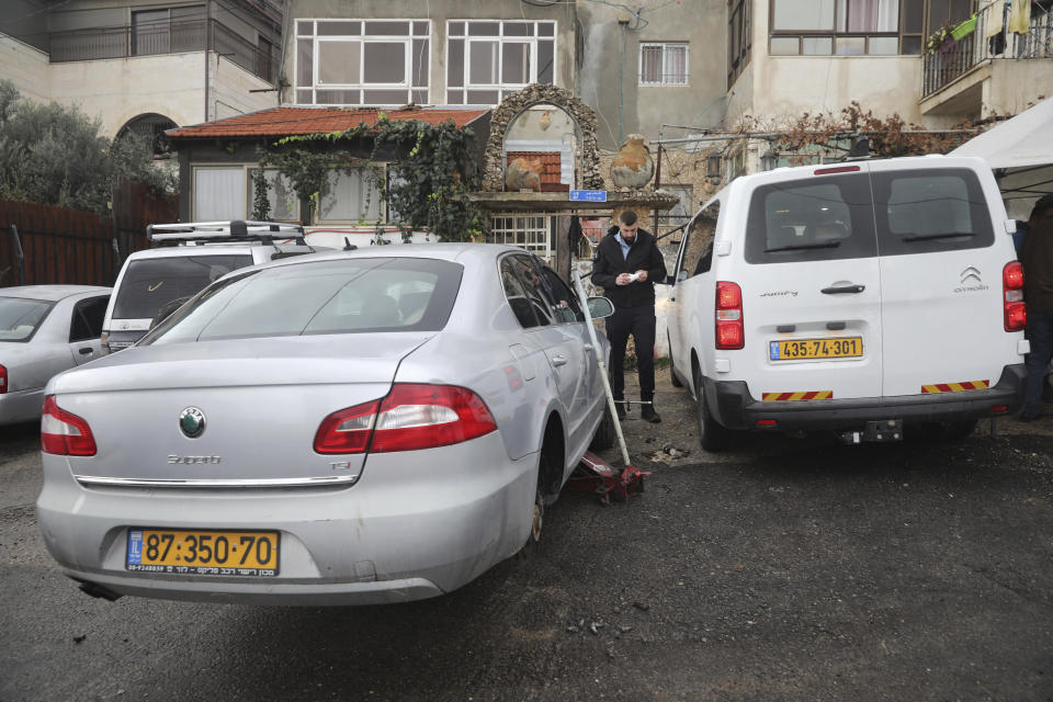 An Israeli police officer stands in the east Jerusalem Palestinian neighborhood of Shuafat, Monday, Dec. 9, 2019. Israeli police say vandals operating under the cover of darkness slashed tires on over 160 cars and sprayed slogans such as "Arabs=enemies" in the Palestinian neighborhood of east Jerusalem. (AP Photo/Mahmoud Illean)