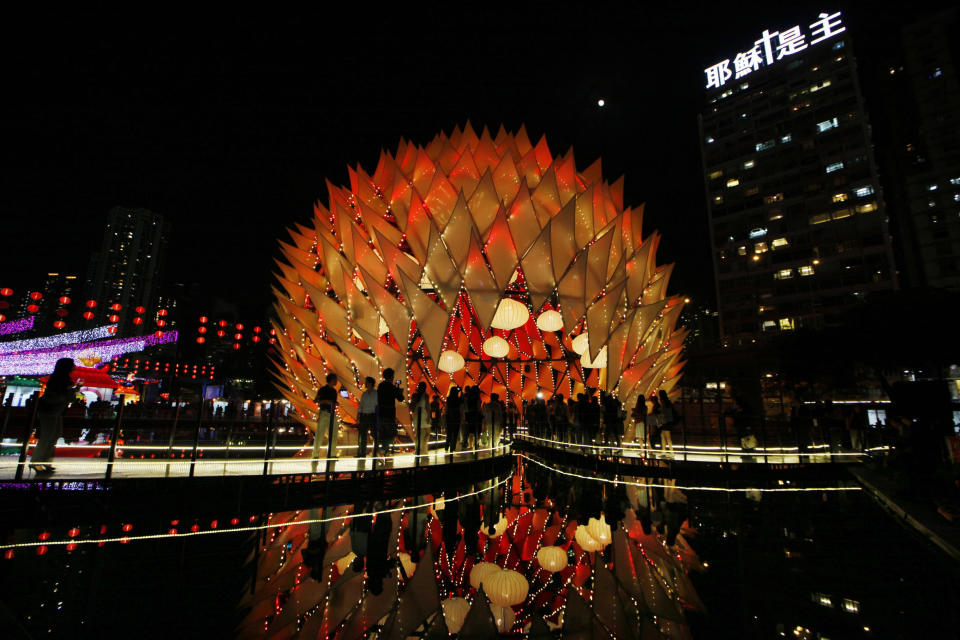 Visitors tour the illuminated decorations and lighting of small bulbs set up at popular Victoria Park to celebrate the Chinese Mid-Autumn Festival in Hong Kong Thursday, Sept. 27, 2012. Like ancient Chinese poets, Hong Kong people appreciate the beauty of the full moon in the Mid-Autumn Festival, which falls on Sunday Sept. 30 this year. (AP Photo/Kin Cheung)