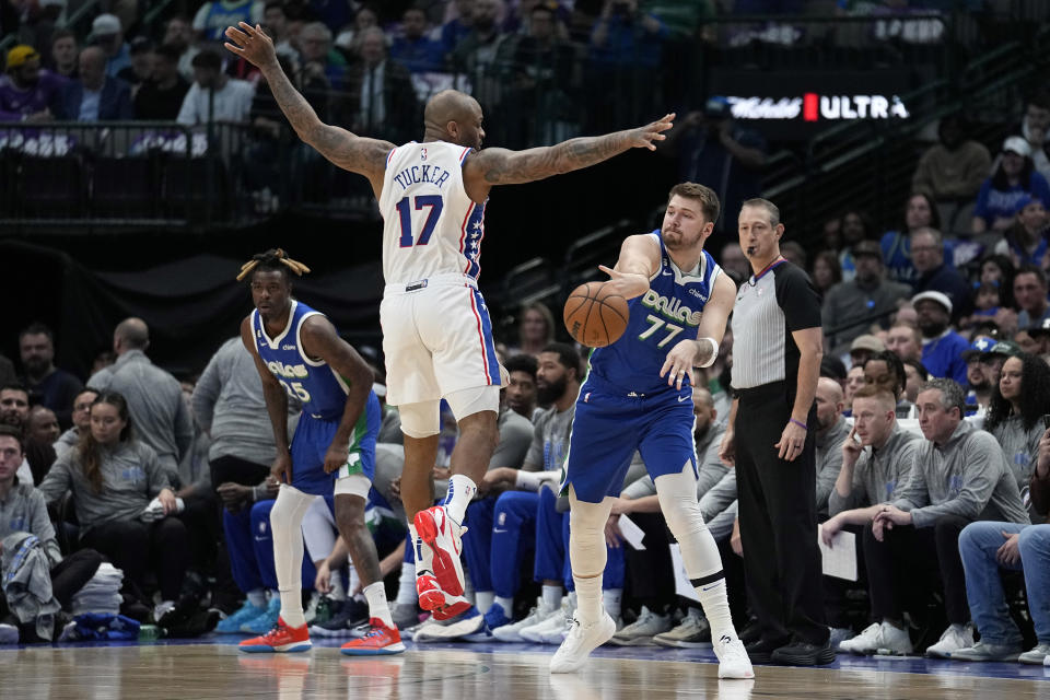 Dallas Mavericks guard Luka Doncic (77) makes a pass as Philadelphia 76ers' P.J. Tucker (17) defends in the first half of an NBA basketball game, Thursday, March 2, 2023, in Dallas. (AP Photo/Tony Gutierrez)