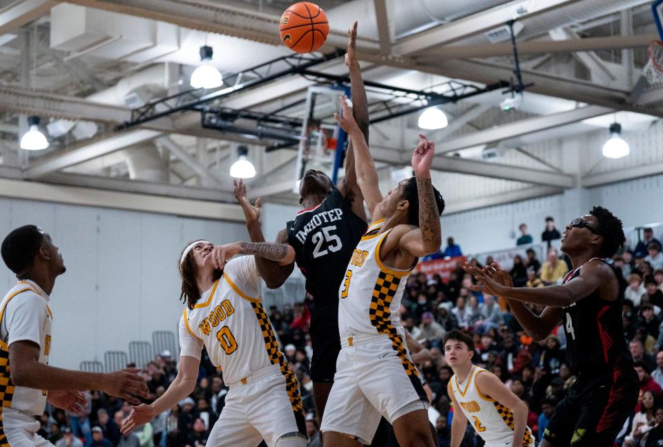 Archbishop Wood's Deuce Maxey (0) and Milan Dean (3) battle for the ball with Imhotep's Jeremiah White (25) in a Dec. 2023 game.