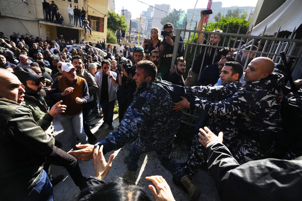 Anti-government protesters scuffle with riot police outside the ministry of Justice, in Beirut, Lebanon, Thursday, Jan. 26, 2023. Scores of protesters Thursday scuffled with riot police as they tried to break into the Beirut Justice Palace, rejecting an order from Lebanon's judiciary that further crippled the probe into a massive port explosion over two years ago. (AP Photo/Hassan Ammar)