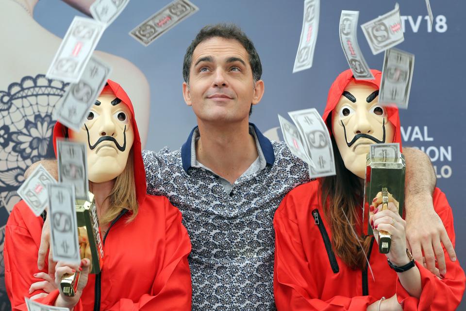 TOPSHOT - Spanish actor Pedro Alonso poses with two women dressed as charaters from the series 