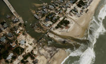 Homes sit in ruin at the end of a bridge (L) wrecked by flooding from Superstorm Sandy on October 31, 2012 in Mantoloking, New Jersey. At least 50 people were reportedly killed in the U.S. by Sandy with New Jersey suffering massive damage and power outages. (Photo by Mario Tama/Getty Images)