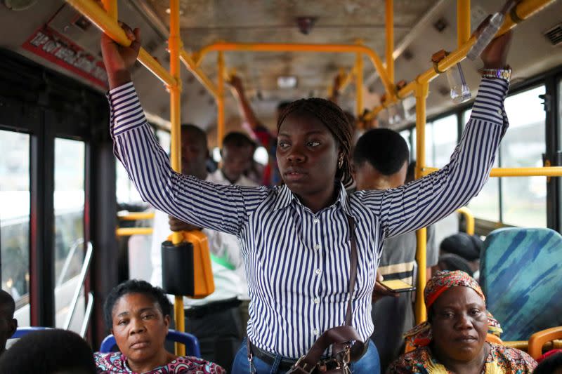 Abisoye Adeniyi, 23, stands in a moving bus as she goes to work in Lagos