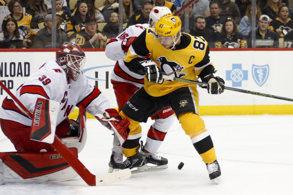 The puck gets behind Pittsburgh Penguins' Sidney Crosby (87) as he tries to gain position infant of Carolina Hurricanes goaltender Alex Nedeljkovic (39) during the second period of an NHL hockey game, Sunday, March 8, 2020, in Pittsburgh. (AP Photo/Keith Srakocic)