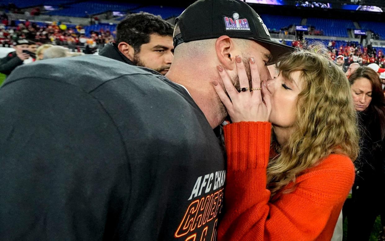 Taylor Swift kisses Kansas City Chiefs tight end Travis Kelce after the AFC Championship game