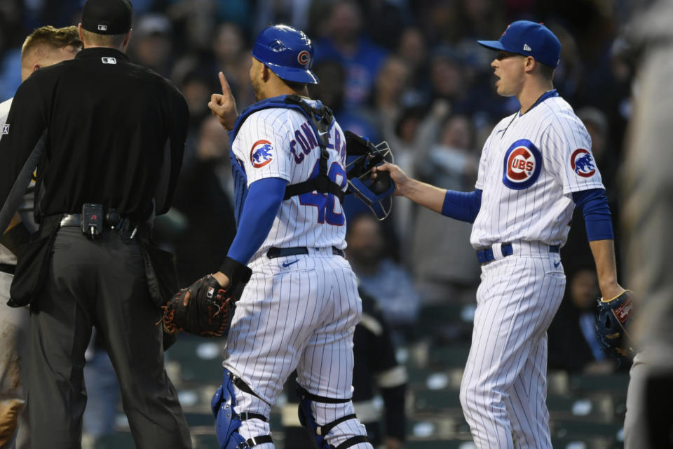 Chicago Cubs catcher Willson Contreras (40) is held back by starting pitcher Keegan Thompson right, after Pittsburgh Pirates' Daniel Vogelbach (19) and Contreras collided at home plate during the fourth inning of a baseball game Tuesday, May 17, 2022, in Chicago. (AP Photo/Paul Beaty)