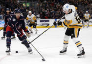 Pittsburgh Penguins forward Jake Guentzel, right, shoots the puck next to Columbus Blue Jackets defenseman Gavin Bayreuther during the first period of an NHL hockey game in Columbus, Ohio, Friday, Jan. 21, 2022. Dumoulin scored on the play. (AP Photo/Paul Vernon)