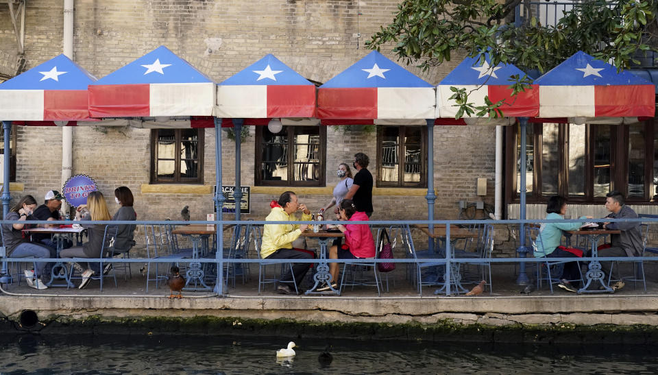 Diners eat at a restaurant on the River Walk, Wednesday, March 3, 2021, in San Antonio. Gov. Greg Abbott says Texas is lifting a mask mandate and lifting business capacity limits next week. (AP Photo/Eric Gay)