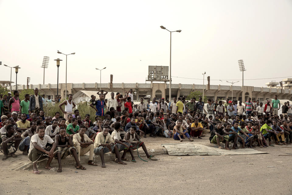 In this July 21, 2019 photo, Ethiopian migrants take shelter in the "22nd May Soccer Stadium," destroyed by war, in Aden, Yemen. Over the summer, the stadium became a temporary refuge for thousands of migrants. At first, security forces used it to house migrants they captured in raids. Other migrants showed up voluntarily, hoping for shelter. The IOM distributed food at the stadium and arranged voluntary repatriation back home for some. The soccer pitch and stands became a field of tents, with clothes lines strung up around them. (AP Photo/Nariman El-Mofty)