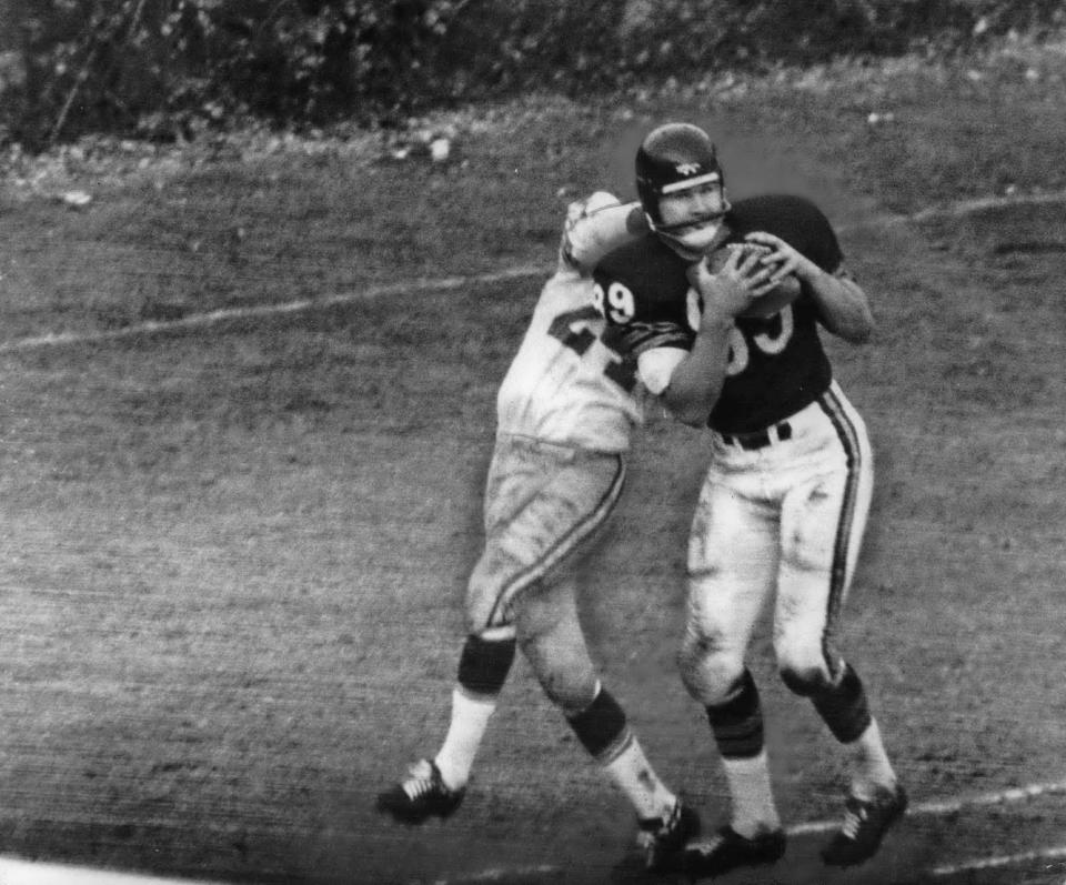 Mike Ditka catches a touchdown pass against the Green Bay Packers' Willie Wood at Chicago during his rookie season. Ditka scored three touchdowns in the game.