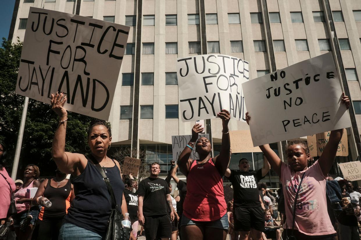 Demonstrators hold "Justice for Jayland" signs as they gather outside Akron City Hall Sunday.