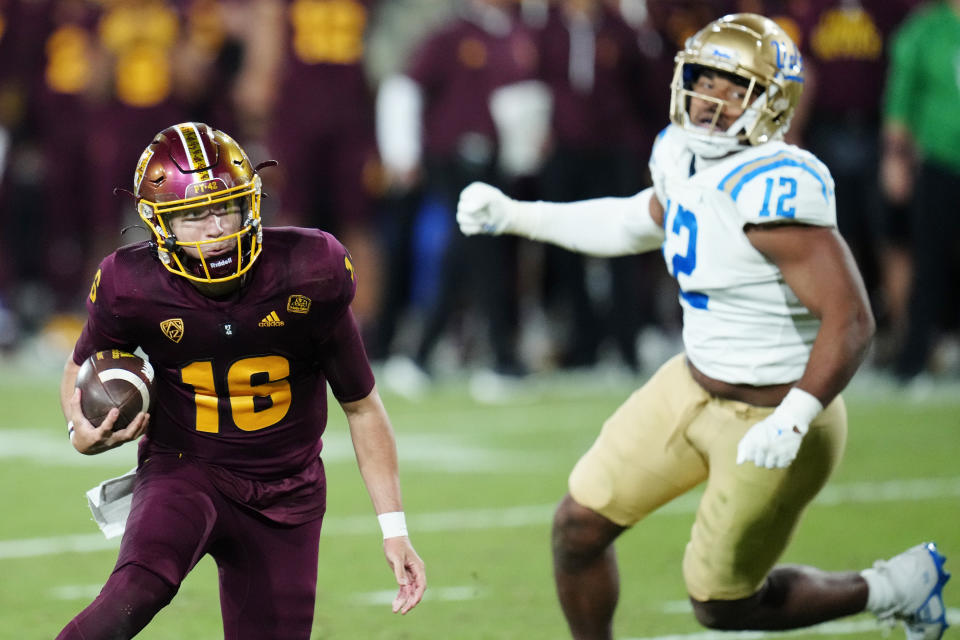 Arizona State quarterback Trenton Bourguet (16) runs past UCLA defensive lineman Grayson Murphy (12) during the second half of an NCAA college football game in Tempe, Ariz., Saturday, Nov. 5, 2022. UCLA won 50-36. (AP Photo/Ross D. Franklin)