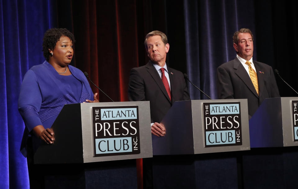 Democratic gubernatorial candidate for Georgia Stacey Abrams, left, speaks as Republican Secretary of State Brian Kemp, and Libertarian Ted Metz, right, look on during a debate Tuesday, Oct. 23, 2018, in Atlanta. (AP Photo/John Bazemore, Pool)