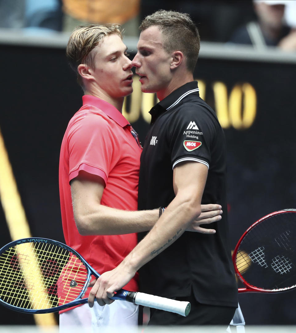 Hungary's Marton Fucsovics, right, is congratulated by Canada's Denis Shapovalov after winning their first round singles match the Australian Open tennis championship in Melbourne, Australia, Monday, Jan. 20, 2020. (AP Photo/Dita Alangkara)