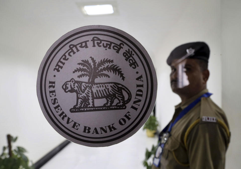A security person stands at the entrance of Reserve Bank of India (RBI) building inMumbai, India, Wednesday, Aug. 7, 2019. India's central bank on Wednesday cut its key interest rate for the fourth consecutive time, reducing the repo rate by 0.35% to 5.40% to shore up the economy, with consumer spending and corporate investment faltering and the production of capital goods and consumer durables decelerating. (AP Photo/Rajanish Kakade)