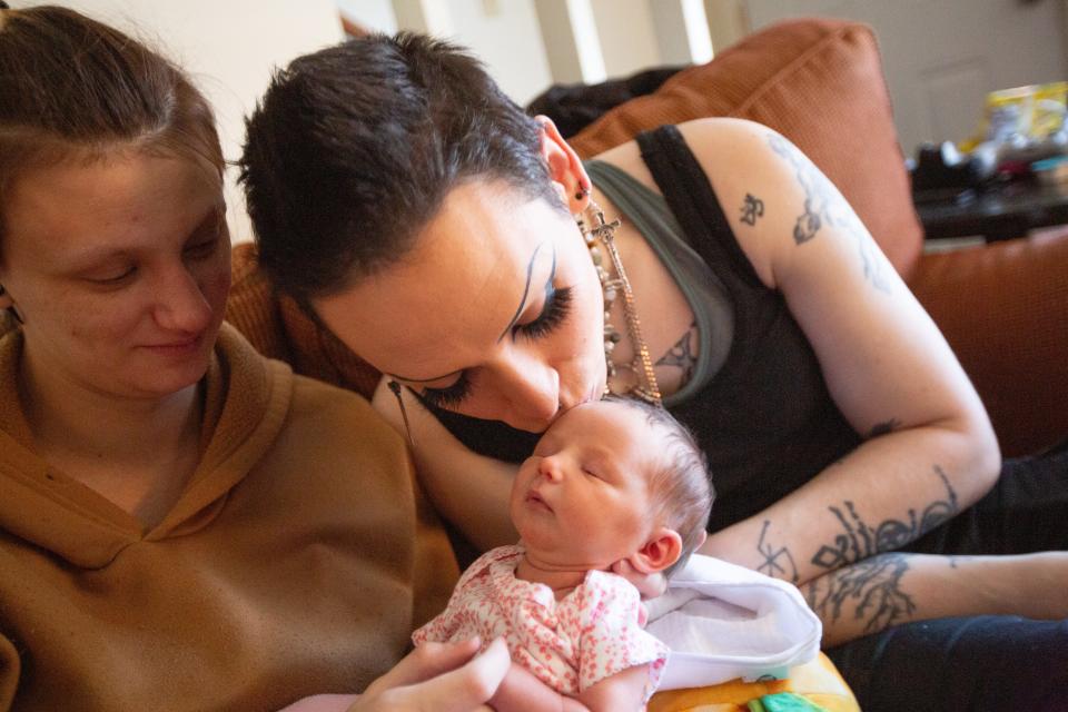 Serana Darkmoon, right, kisses her newborn daughter, Delilah, on the forehead while Delilah is being held by Darkmoon's partner Austin Dalton on Monday morning.