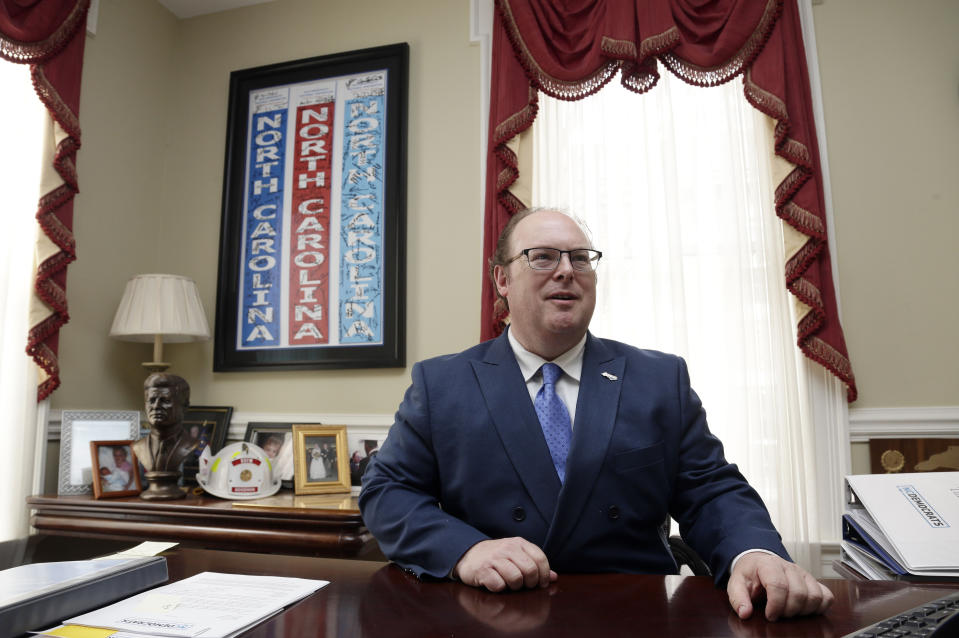 State Democratic Party Chairman Wayne Goodwin speaks with an aide in his office at the Democratic party headquarters in Raleigh, N.C., Friday, April 5, 2019. Goodwin spoke to The Associated Press on Friday in his first interview since federal bribery and conspiracy charges were lodged against donor Greg Lindberg and state Republican Party Chairman Robin Hayes. (AP Photo/Gerry Broome)