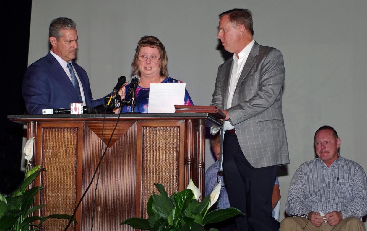 Attorneys Eric Bland, at left, and Ronnie Richter support an emotional, teary-eyed Ginger Hadwin during Thursday's announcement of the Gloria's Gift Foundation.