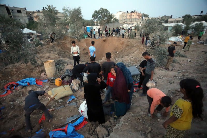 Palestinians search for belongings from their destroyed tents following Israeli airstrikes in town of Rafah, southern Gaza Strip on April 22. Israeli Prime Minister Benjamin Netanyahu said Israel will invade the city "with or without" a hostage deal. Photo by Ismael Mohamad/UPI