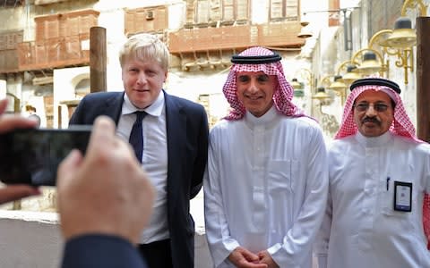 Saudi Foreign Minister Adel al-Jubeir (C) and his British counterpart Boris Johnson (L) pose for a picture during a tour of the historic quarter of Jeddah - Credit: AFP