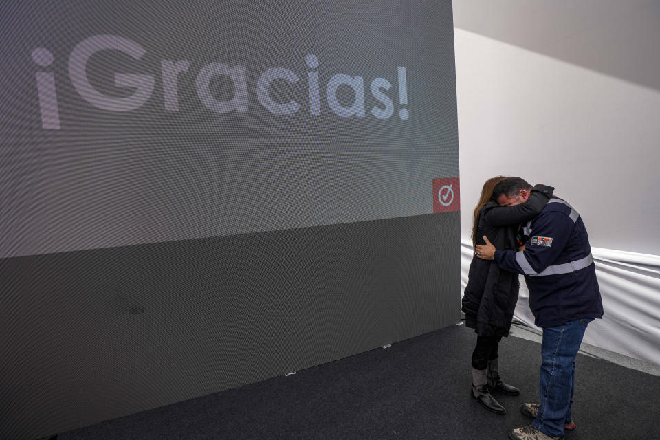 Workers from the Ventanas Smelter, which belongs to the state-owned company Codelco, hug on the sidelines of a closure ceremony on the first day of its closing in Quintero Bay in Puchuncavi, Chile, Wednesday, May 31, 2023. Chilean President Gabriel Boric announced in June 2022 the gradual closure of the world's leading copper producer in order to reduce the constant episodes of environmental pollution that affect the coastal communes near the furnace. (AP Photo/Esteban Felix)