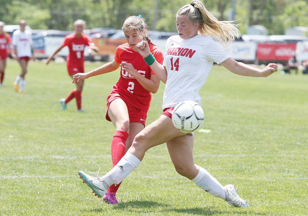 Dallas Center-Grimes' mid-fielder Olivia Cyr (2) kicks the ball for a goal around Marion's mid-fielder Emily Dooley (14) during the 2A girls' state quarterfinal at Cownie Soccer Complex on Wednesday, May 31, 2023, in Des Moines.