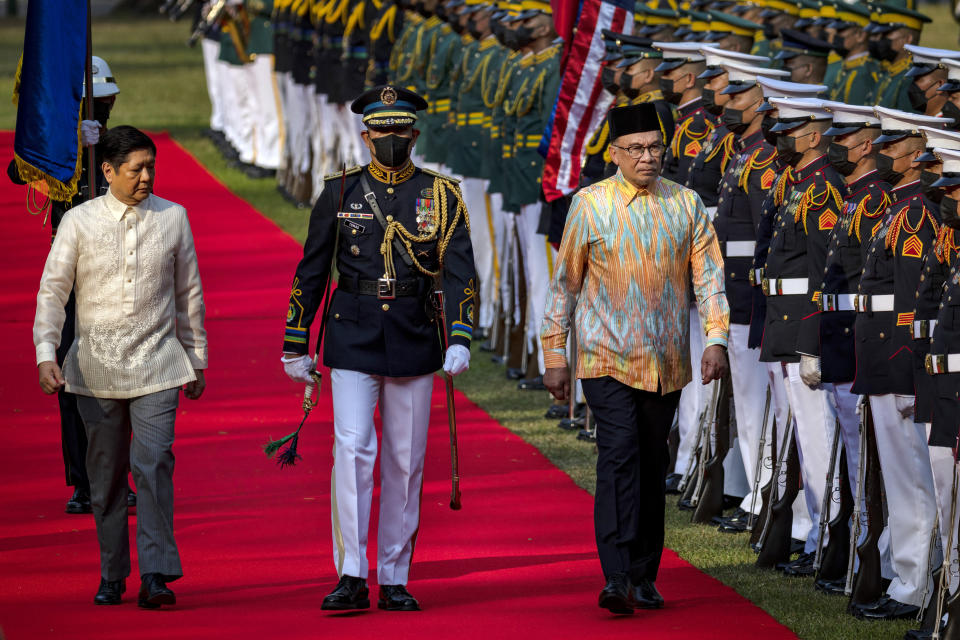 Malaysian Prime Minister Anwar Ibrahim, right, and Philippine President Ferdinand Marcos Jr., left, review honor guards during a welcome ceremony at Malacanang Palace in Manila, Philippines, Wednesday March 1, 2023. Anwar Ibrahim is in Manila to hold talks with President Marcos in an effort to boost bilateral ties between the two countries. (Ezra Acayan/Pool via AP)