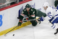 Minnesota Wild right wing Ryan Hartman (38) and Toronto Maple Leafs defenseman Rasmus Sandin (38) battle for the puck during the first period of an NHL hockey game, Saturday, Dec. 4, 2021, in St. Paul, Minn. (AP Photo/Andy Clayton-King)