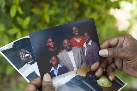 Anthony Scott, brother of Walter Scott, holds a 2005 photo of Walter Scott and his children in Charleston, South Carolina April 9, 2015. The children are (L-R) Miles, Sebastian, Samantha and Walter Jr.REUTERS/Randall Hill