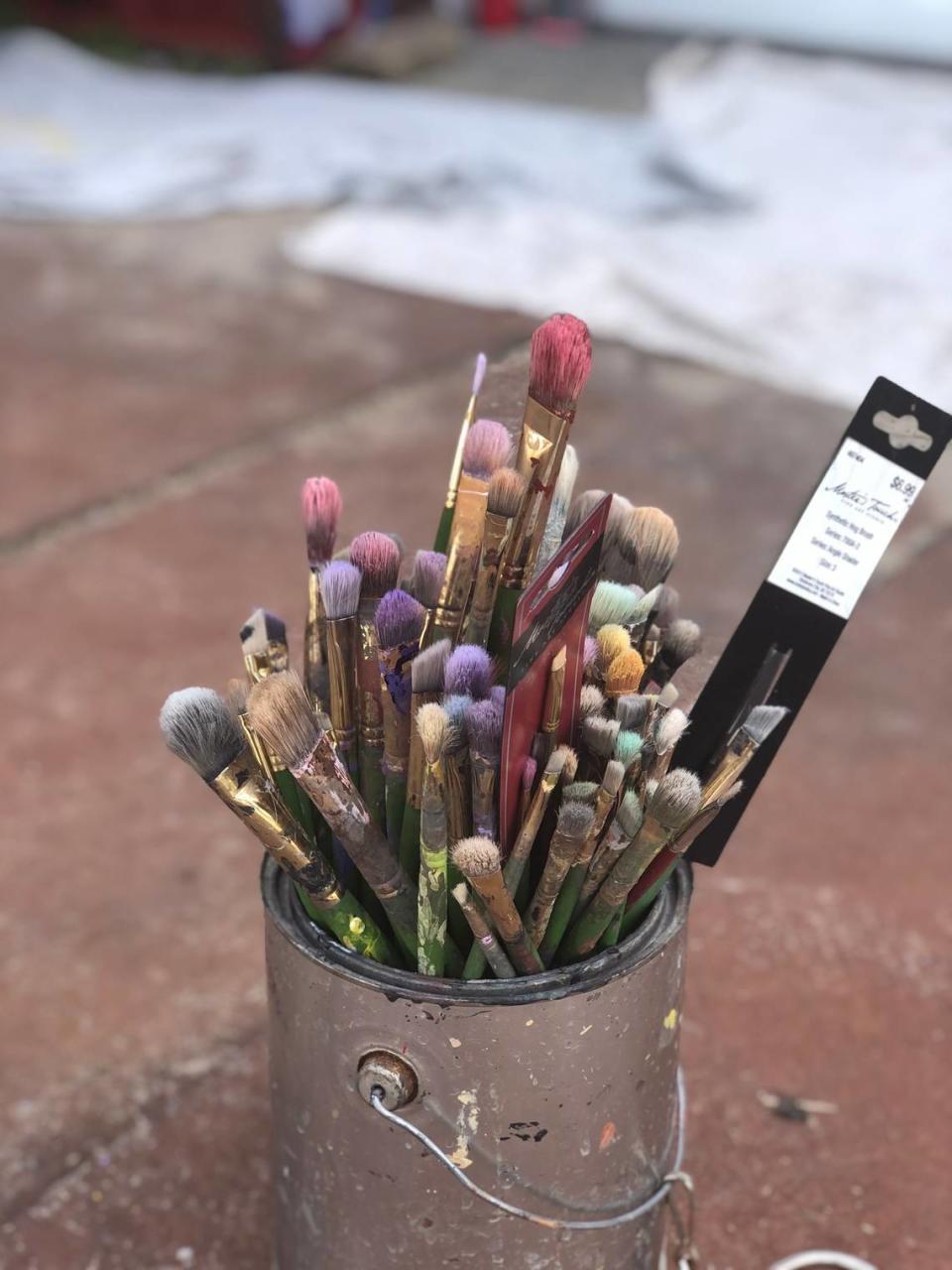 A bucket of brushes, tools of the muralist’s trade, on site at the Red Wolf Center in Pocosin Lakes National Wildlife Refuge.