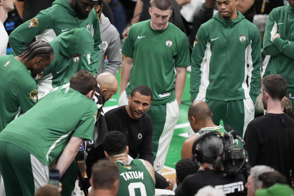 Boston Celtics head coach Joe Mazzulla, center, speaks to his players during a timeout in the first half of Game 5 of the NBA basketball finals against the Dallas Mavericks, Monday, June 17, 2024, in Boston. (AP Photo/Charles Krupa)