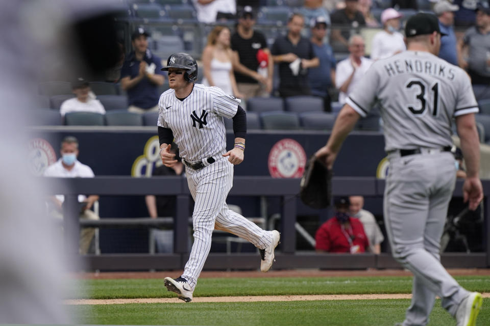 New York Yankees Clint Frazier (77) trots home to score the game-winning run on a bases-loaded walk as Chicago White Sox relief pitcher Liam Hendriks (31) leaves the mound during the ninth inning of a baseball game, Sunday, May 23, 2021, at Yankee Stadium in New York. The Yankees defeated the White Sox 5-4 after Hendriks walked Aaron Judge. (AP Photo/Kathy Willens)