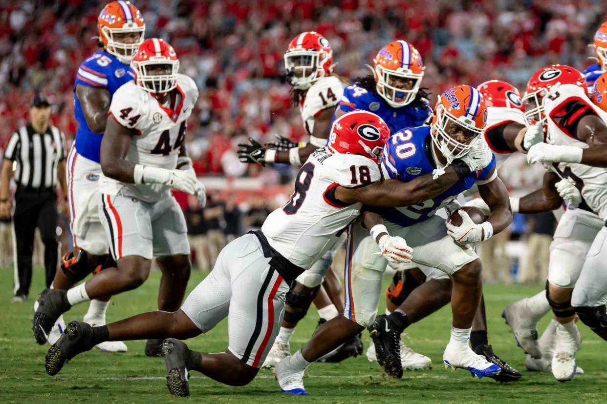 Georgia Bulldogs linebacker Xavian Sorey Jr. (18) tackles Florida Gators running back Treyaun Webb (20) during the second half at Everbank Stadium in Jacksonville, FL on Saturday, October 28, 2023. [Matt Pendleton/Gainesville Sun]