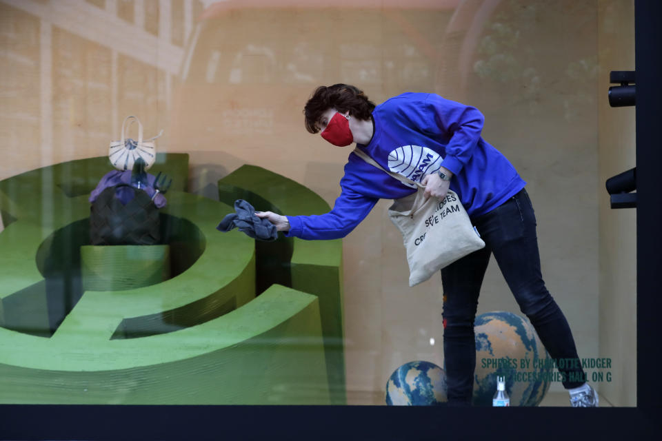 A worker cleans a Selfridges department store shop window on Oxford Street in London, Monday, April 12, 2021. Millions of people in England will get their first chance in months for haircuts, casual shopping and restaurant meals on Monday, as the government takes the next step on its lockdown-lifting road map. (AP Photo/Kirsty Wigglesworth)